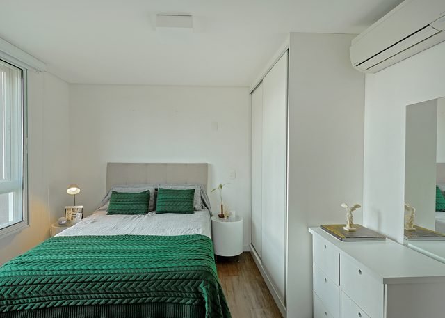 Suíte confortável com roupa de cama em tons de verde